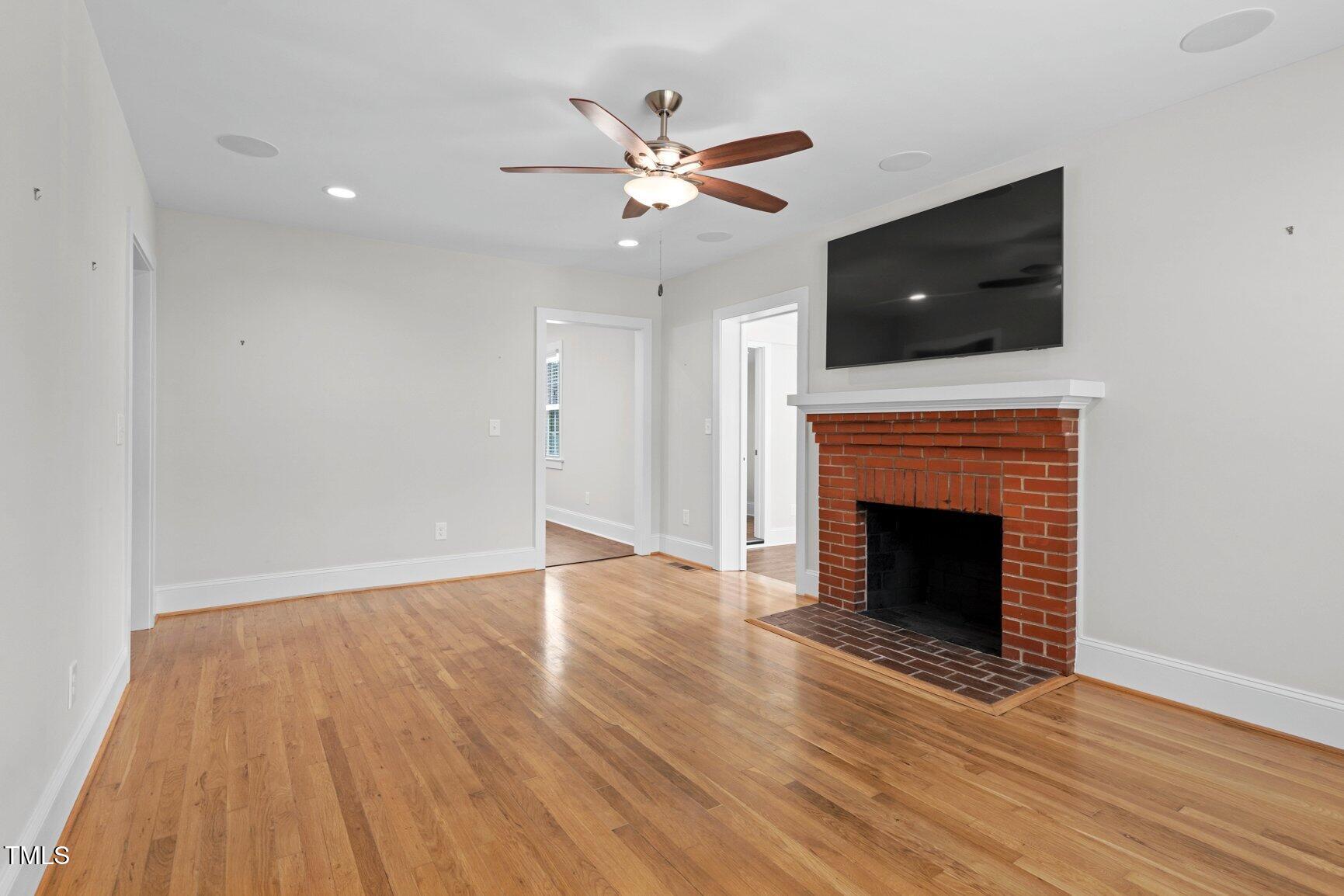 216 Whitfield Street Enfield, NC 27823 - Photo 6 of 31 a view of an empty room with wooden floor and a fireplace