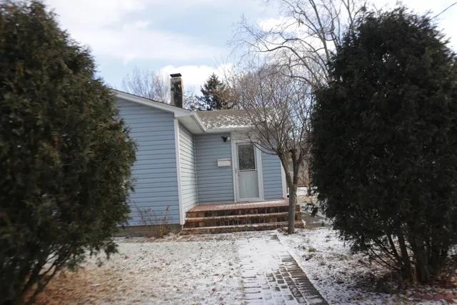 a view of a house with a yard covered in snow