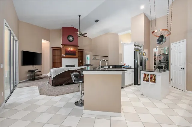a kitchen with stainless steel appliances kitchen island granite countertop a refrigerator and a sink