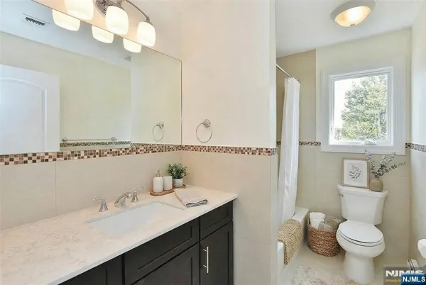 a bathroom with a granite countertop sink a toilet and a mirror
