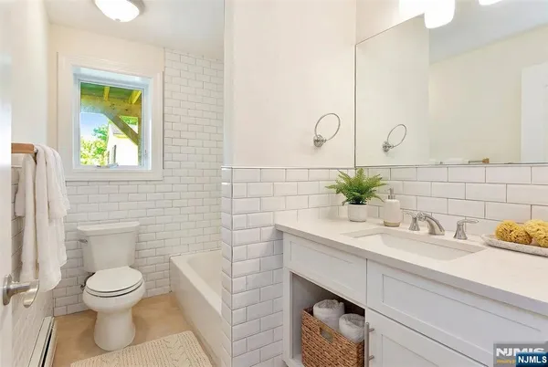 a bathroom with a sink a toilet and a mirror