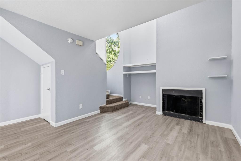 620 West Union Bower Road Irving, TX 75061 - Photo 11 of 22 Unfurnished living room with a fireplace and light wood-style floors