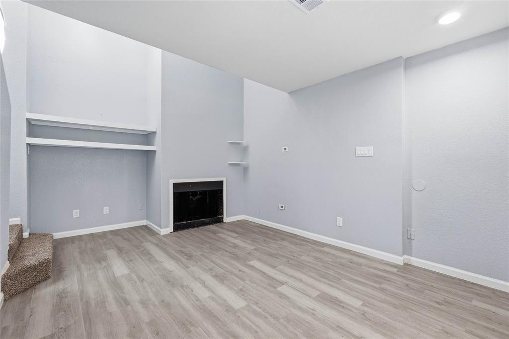 620 West Union Bower Road Irving, TX 75061 - Photo 12 of 22 Unfurnished living room with light wood finished floors and a fireplace