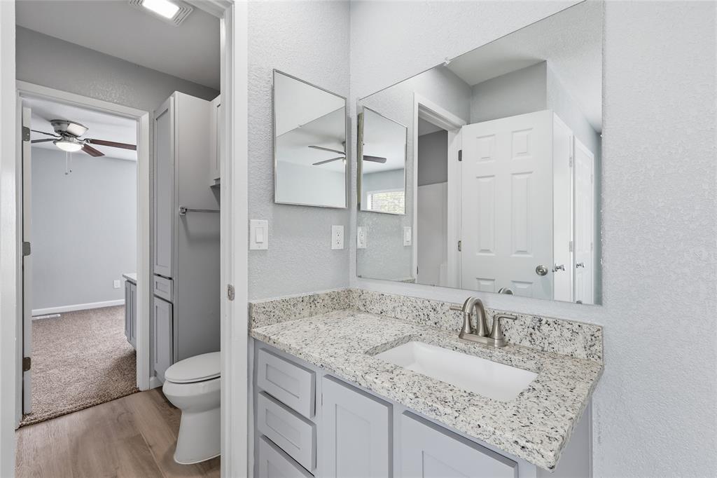 620 West Union Bower Road Irving, TX 75061 - Photo 18 of 22 Bathroom with vanity, a textured wall, light wood-style floors, and a ceiling fan