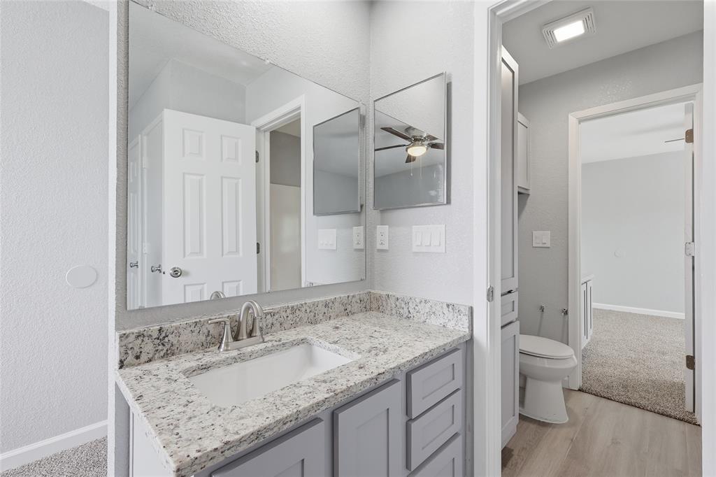 620 West Union Bower Road Irving, TX 75061 - Photo 19 of 22 Bathroom featuring vanity, a textured wall, and light wood finished floors