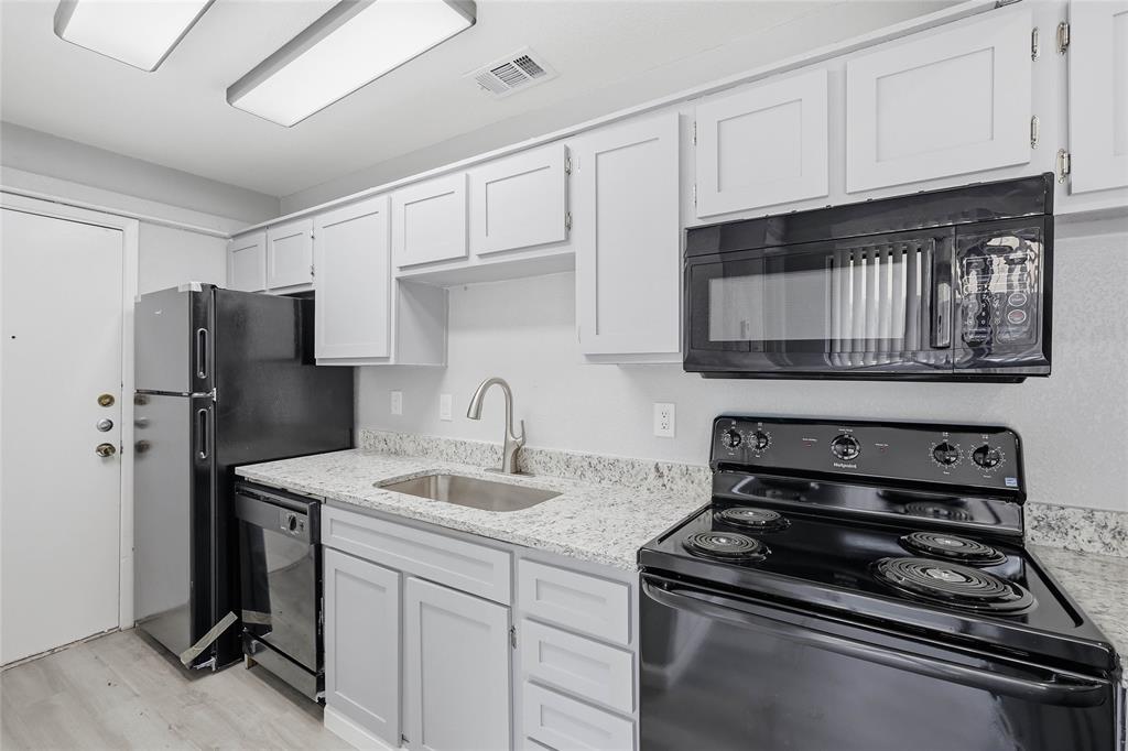 620 West Union Bower Road Irving, TX 75061 - Photo 5 of 22 Kitchen featuring black appliances, light stone counters, white cabinets, and light wood-style flooring
