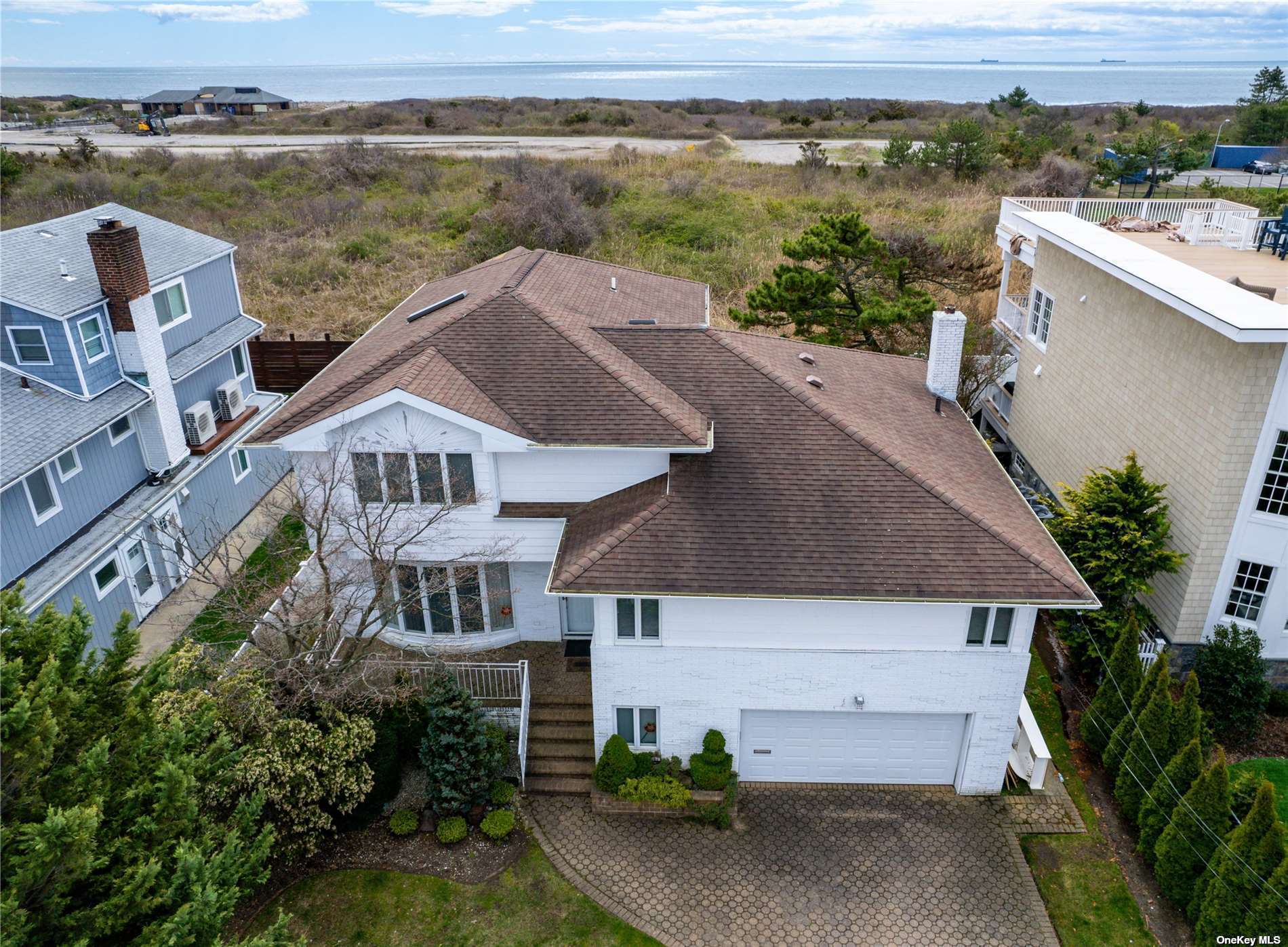 an aerial view of a house with a yard and ocean view