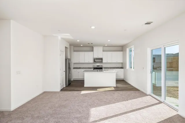 a kitchen with a refrigerator and white cabinets