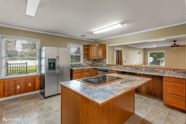 a kitchen with stainless steel appliances granite countertop a sink and a refrigerator