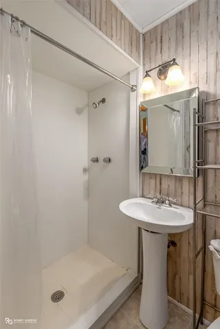 a bathroom with a shower a mirror and a sink