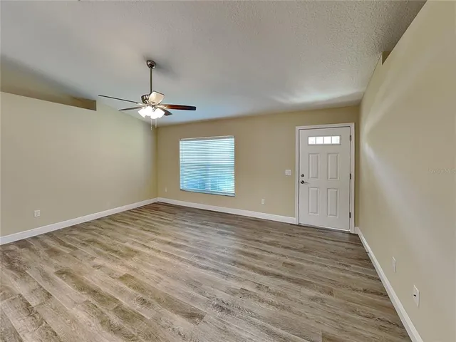 a view of an empty room with wooden floor
