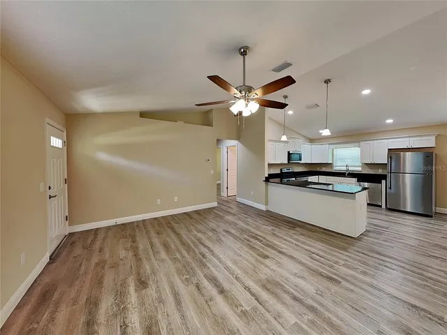 a view of kitchen with sink and refrigerator