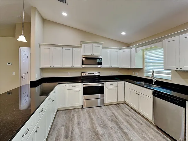 a kitchen with granite countertop a stove and a sink