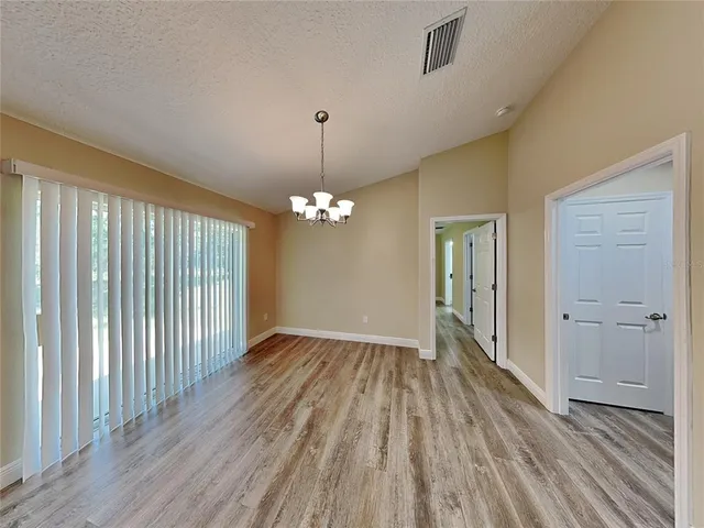 a view of livingroom with hardwood floor and kitchen space