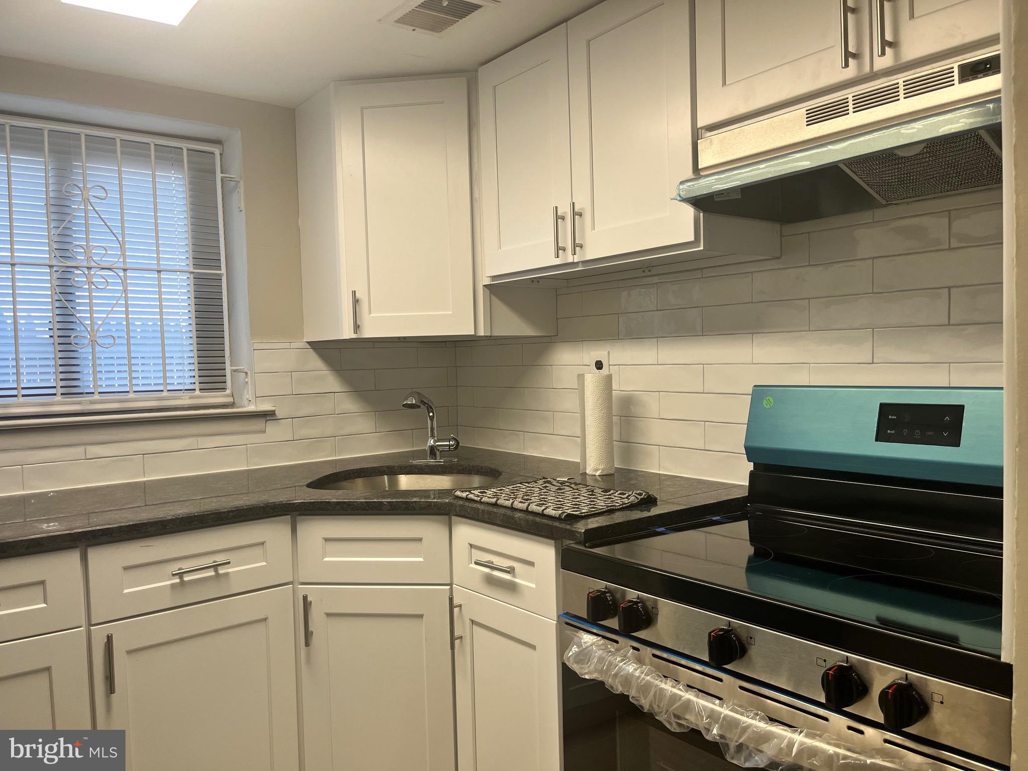 8030 Ditman Street, Unit 44H Philadelphia, PA 19136 - Photo 24 of 25 a kitchen with a stove and white cabinets
