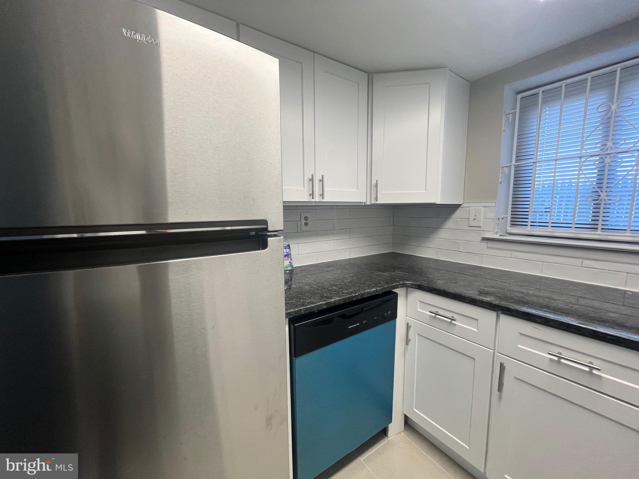 8030 Ditman Street, Unit 44H Philadelphia, PA 19136 - Photo 25 of 25 a kitchen with granite countertop white cabinets and white appliances