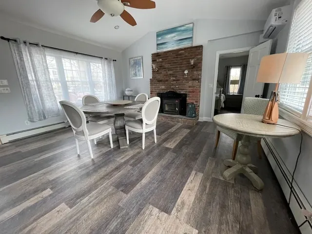 a dining room with furniture a fireplace and wooden floor
