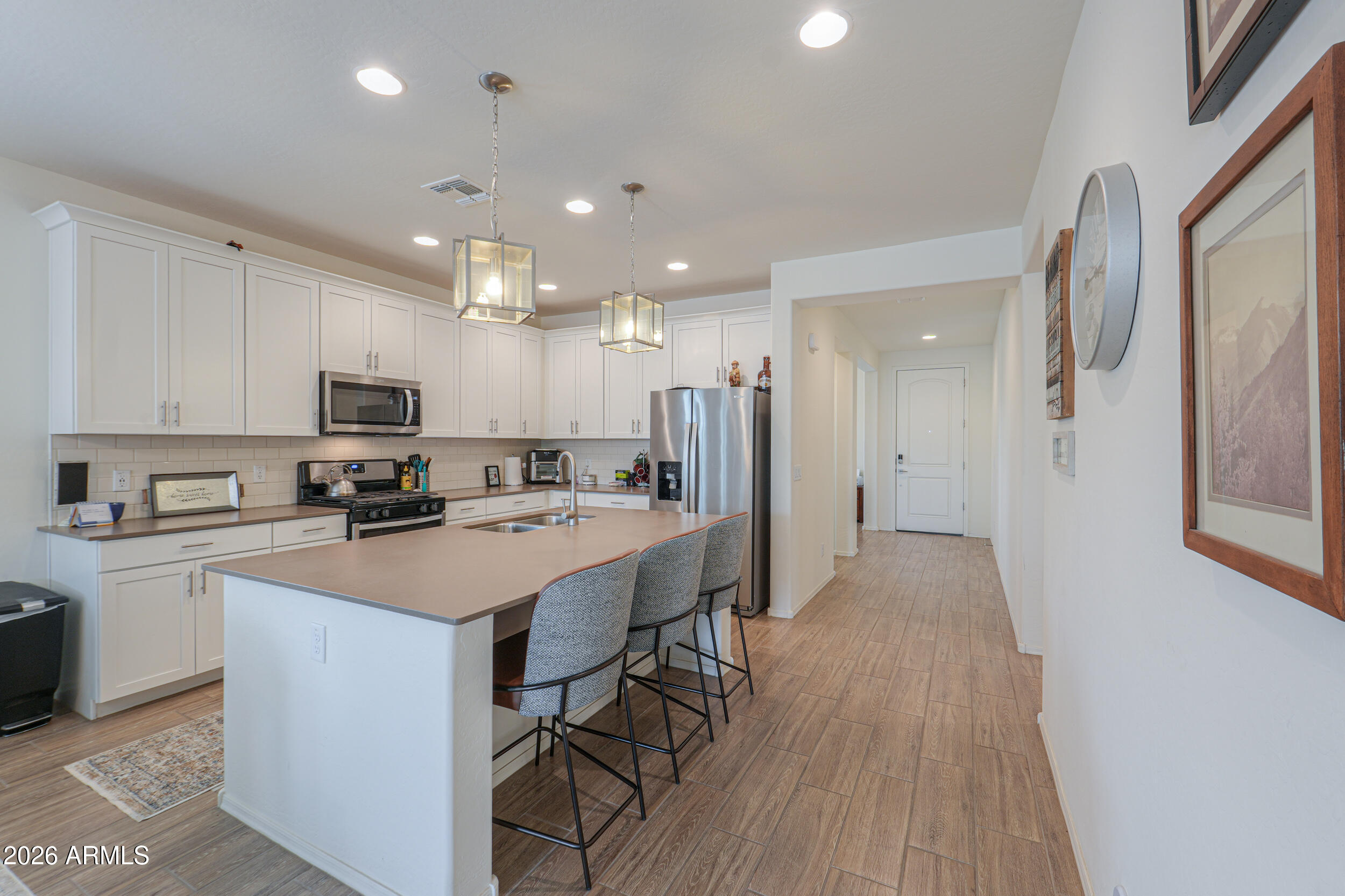 42085 West Cribbage Road Maricopa, AZ 85138 - Photo 9 of 35 a kitchen with a sink a refrigerator and a stove top oven
