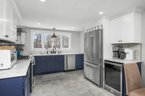 a kitchen with granite countertop a refrigerator and a stove top oven