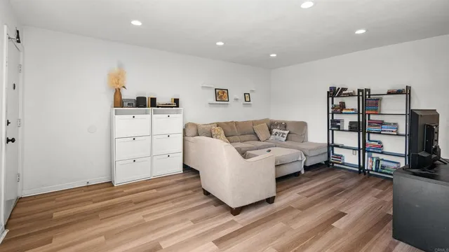 a living room with furniture and a wooden floor