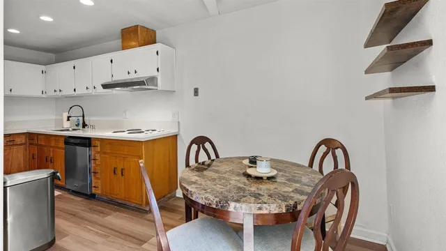 a kitchen with stainless steel appliances a sink a table and chairs