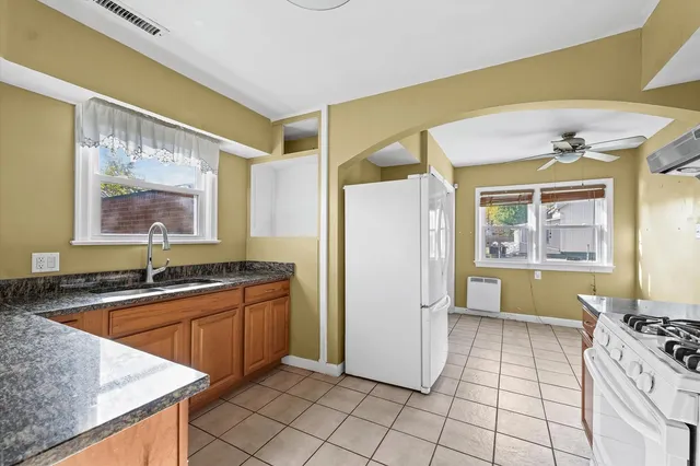 a kitchen with granite countertop a sink and a refrigerator