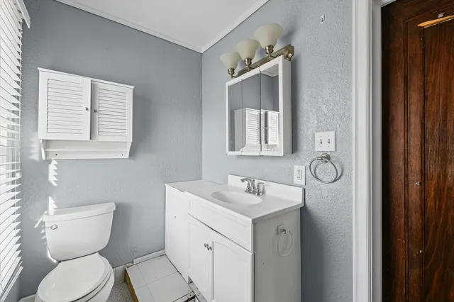 a bathroom with a toilet sink and mirror