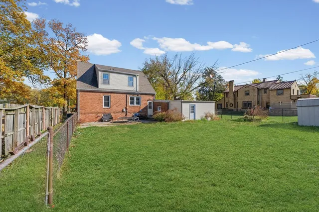 a view of a house with backyard and a tree