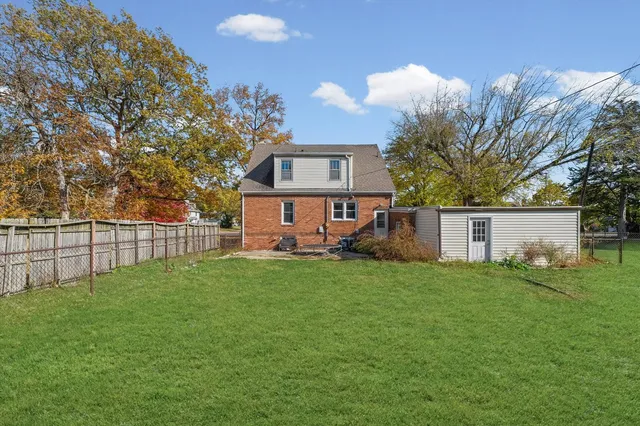 a view of a house with backyard and a tree