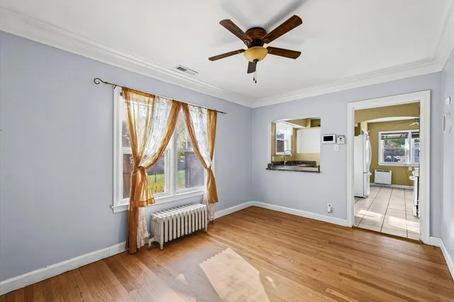 an empty room with a window and wooden floor