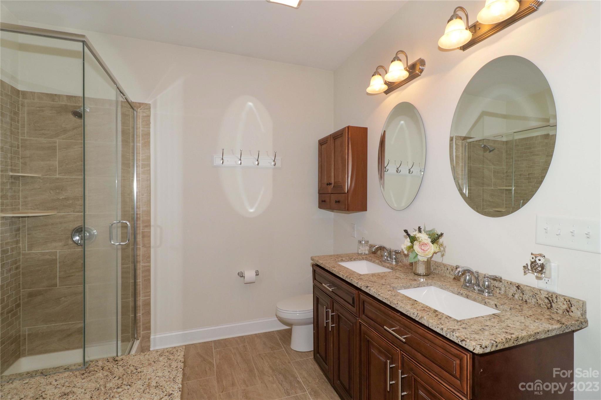 117 Windstone Drive Troutman, NC 28166 - Photo 22 of 40 a bathroom with a granite countertop sink a mirror and a shower