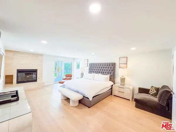 a spacious bedroom with a bed couch and a fireplace
