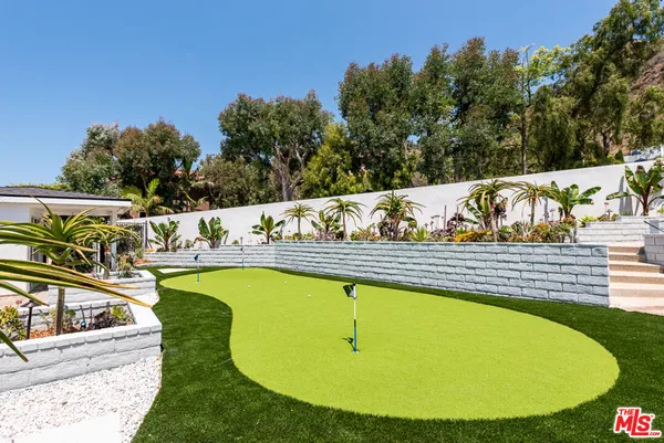 a view of swimming pool with outdoor seating and trees in the background