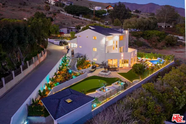 an aerial view of a house yard swimming pool and outdoor seating