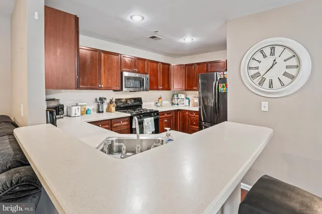 a kitchen with a table chairs a stove a microwave and cabinets