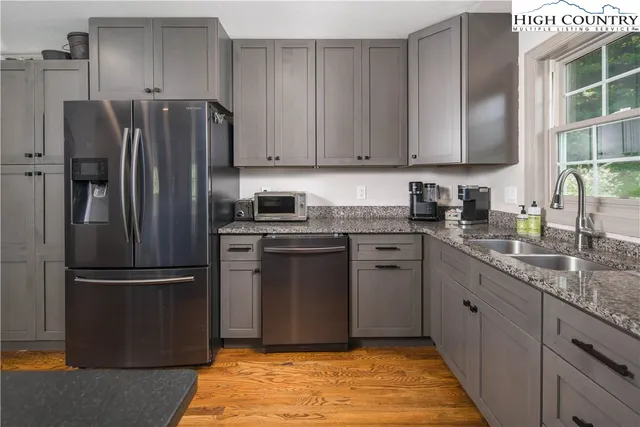 a kitchen with stainless steel appliances granite countertop a refrigerator a stove top oven a sink and dishwasher