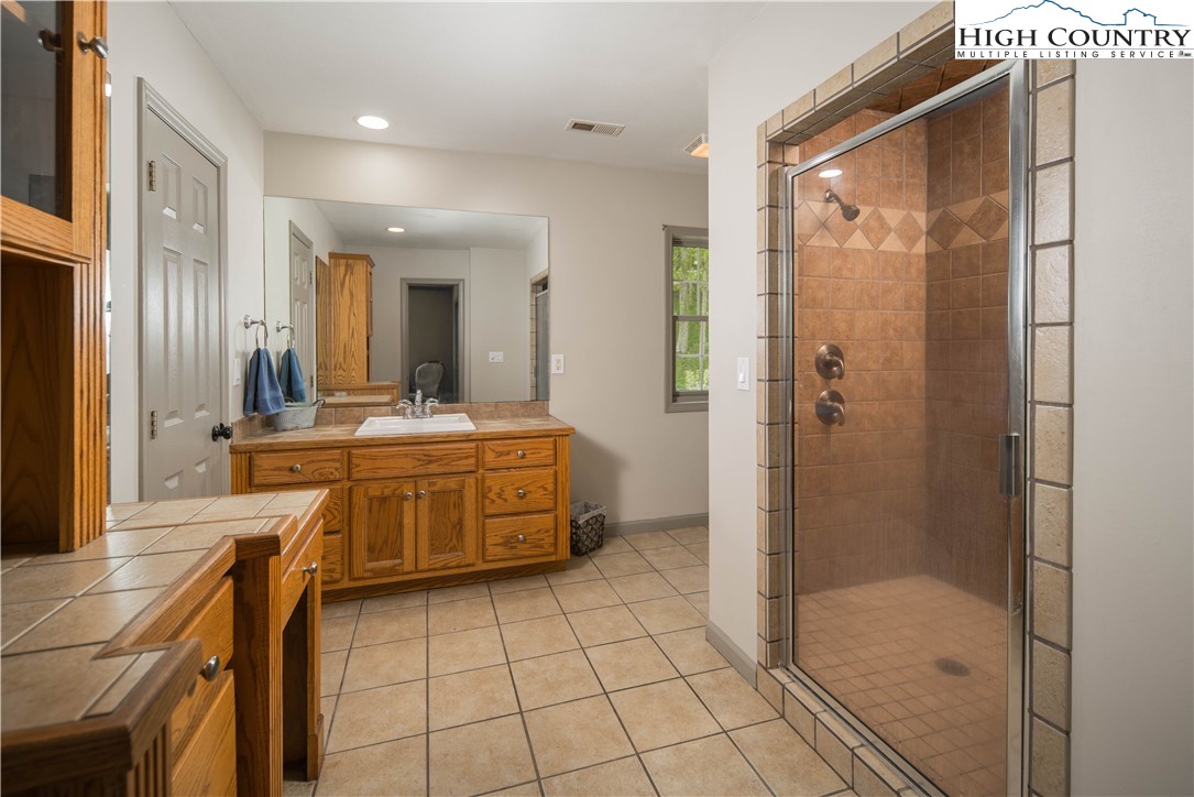 1527 Mabel School Road Zionville, NC 28698 - Photo 26 of 49 a bathroom with a double vanity sink a mirror and a shower