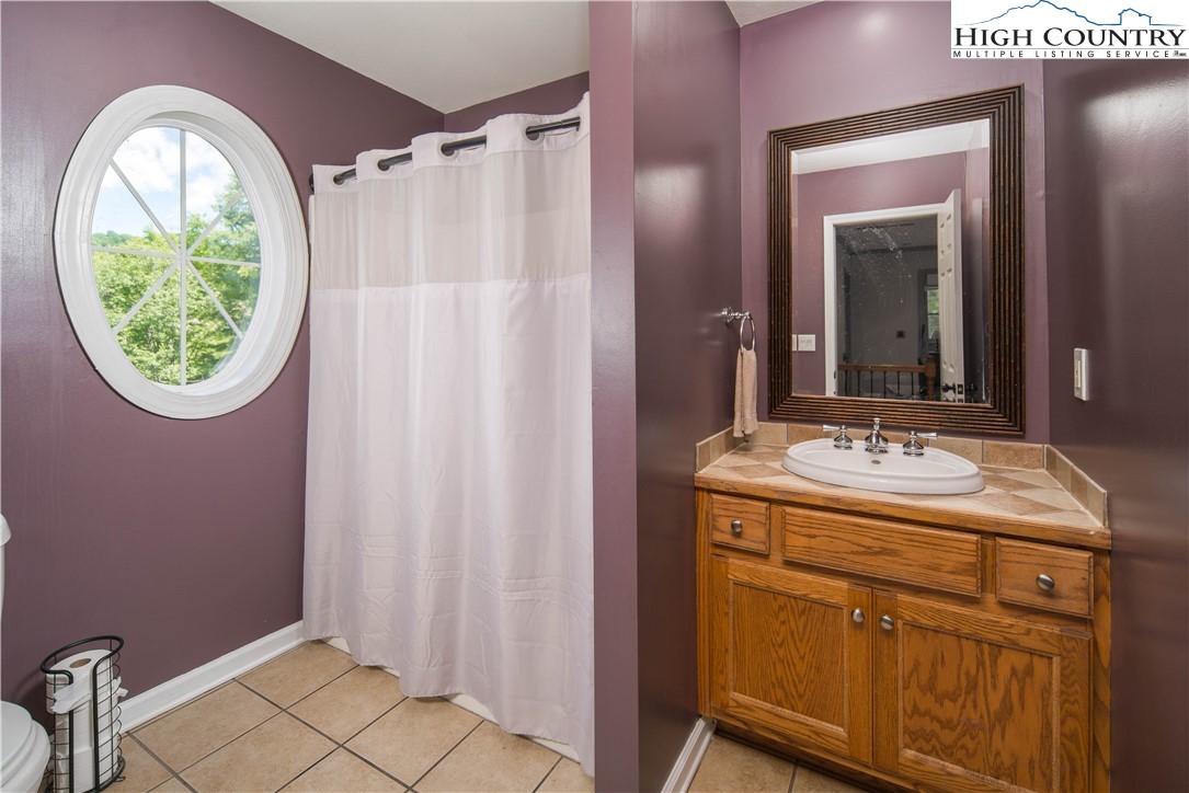 1527 Mabel School Road Zionville, NC 28698 - Photo 31 of 49 a bathroom with a granite countertop sink a mirror and a shower