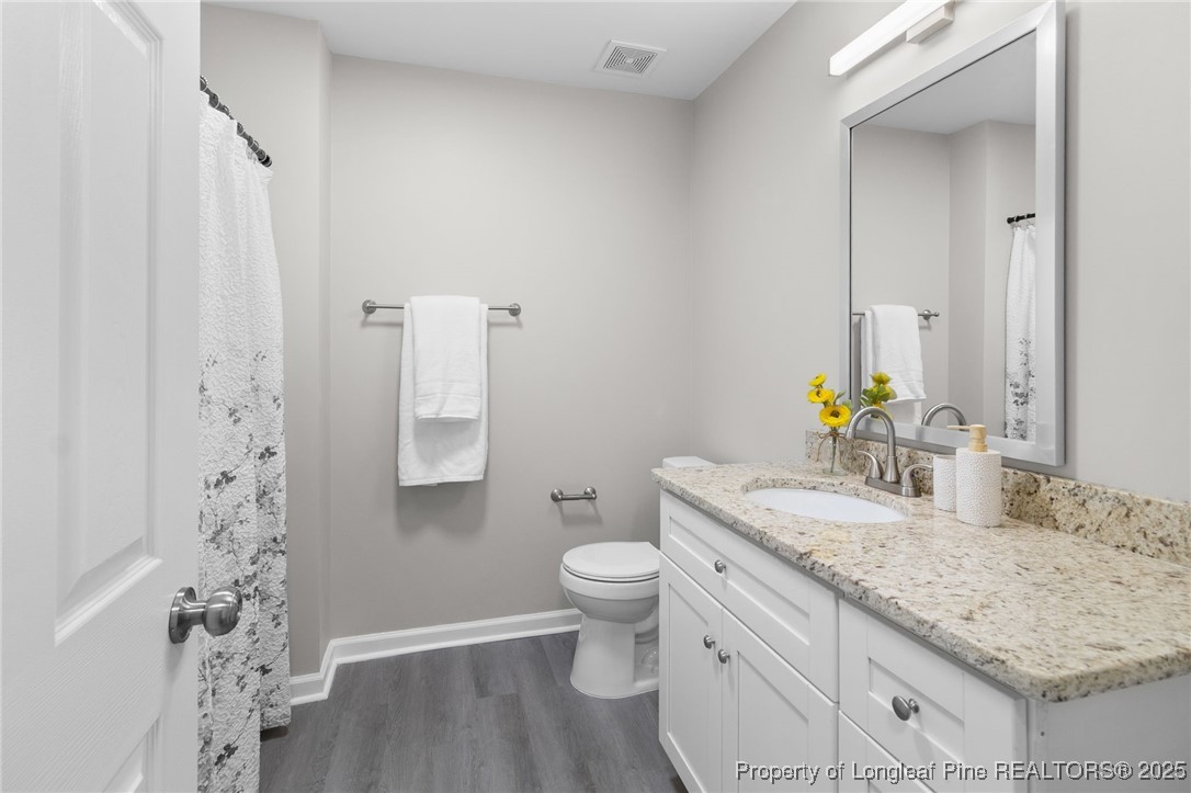 516 Heathrow Drive Spring Lake, NC 28390 - Photo 33 of 42 a bathroom with a granite countertop sink toilet and mirror