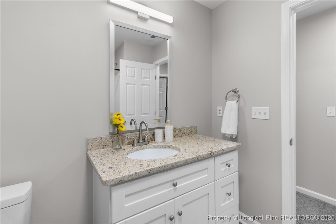 516 Heathrow Drive Spring Lake, NC 28390 - Photo 34 of 42 a bathroom with a granite countertop sink and a mirror