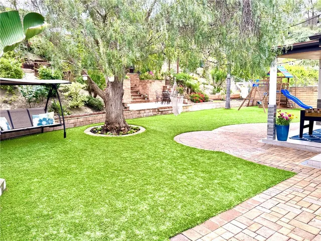 a view of a chair and table in backyard of the house
