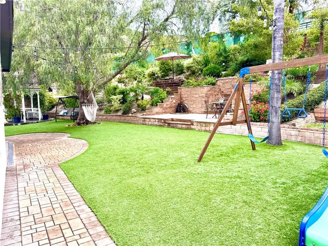 a view of a backyard with a slide and a child swing