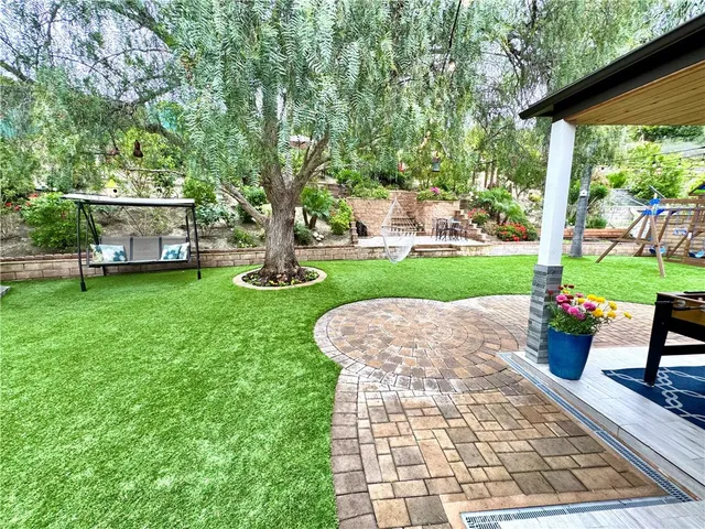 a view of backyard with swimming pool and green space