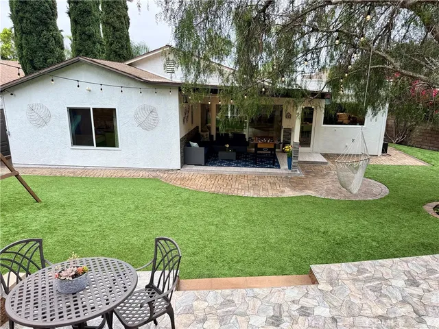 a view of a house with backyard and sitting area