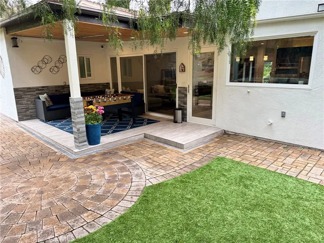 a view of a patio with chairs and table under an umbrella