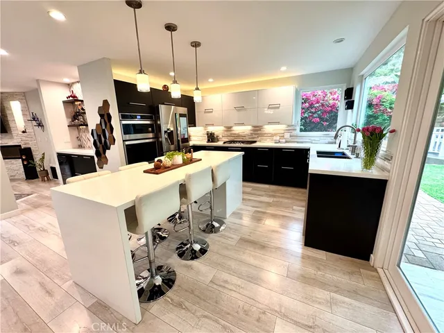 a kitchen with a sink a stove and chairs
