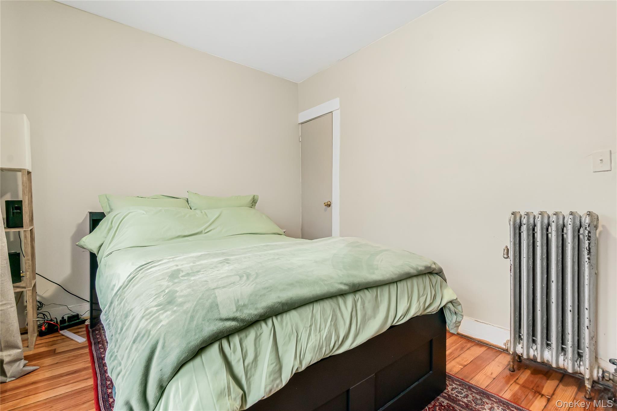 85-14 Sutter Avenue Queens, NY 11417 - Photo 18 of 27 Bedroom featuring radiator, closet, and hardwood floors