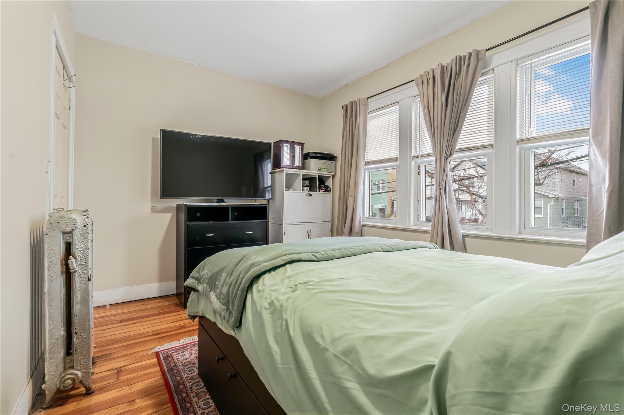 85-14 Sutter Avenue Queens, NY 11417 - Photo 19 of 27 Bedroom with light wood floors and radiator