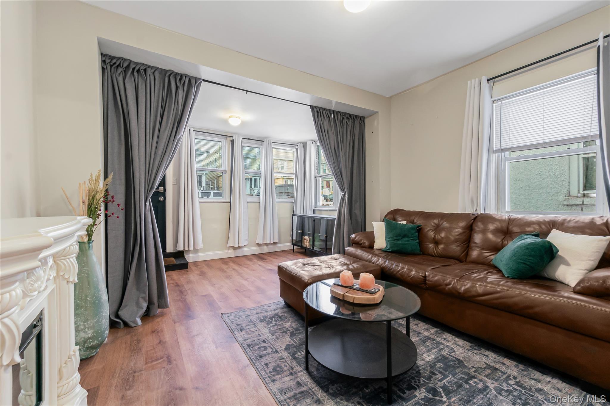 85-14 Sutter Avenue Queens, NY 11417 - Photo 5 of 27 Living area featuring plenty of natural light, wood finished floors, and a fireplace