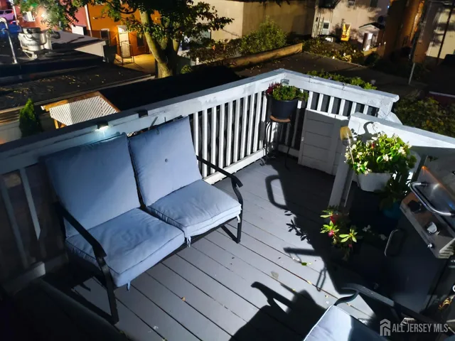 a balcony with wooden floor outdoor seating and flowers